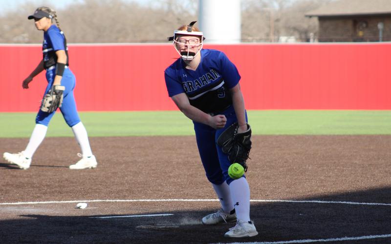 (TC GORDON | THE GRAHAM LEADER) Graham pitcher Reese Calhoun releases a pitch during warmups before an inning in the team’s 9-1 win over Stamford. The Lady Blues took on Burkburnett the day after and fell 8-7.