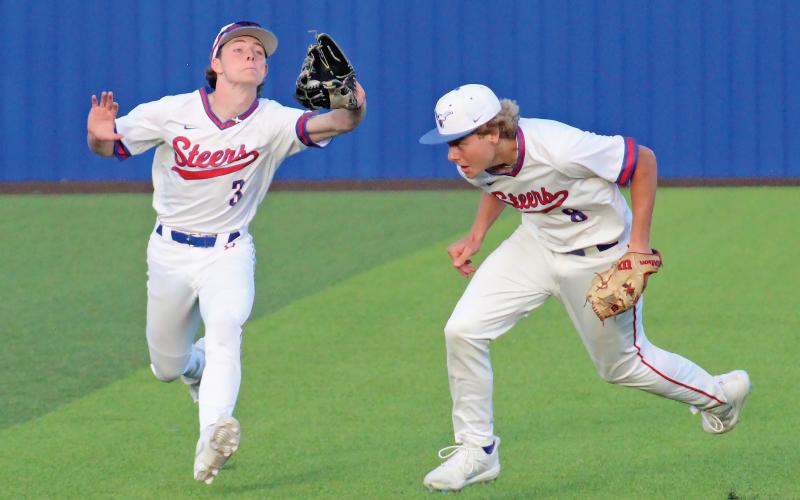 (TC GORDON | THE GRAHAM LEADER) Senior left fielder Luke McCain (3) runs to make a catch on a fly ball while junior shortstop Harison Brockway gets out of the way to avoid a collision during Graham’s 4-3 win Tuesday, March 19 over Mineral Wells.