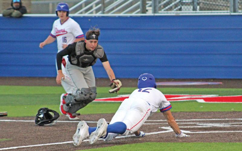 (TC GORDON | THE GRAHAM LEADER) Junior right fielder Ty Thompson dives into home plate and beats the tag from Mineral Wells’ catcher to score a run during Graham’s 4-3 win over the Rams this past Tuesday, March 19.
