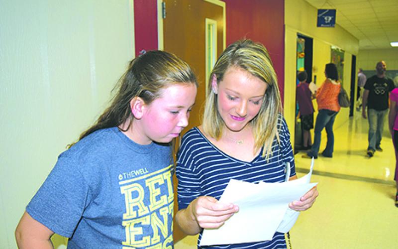 Claire Adams and Aubrey Johnston compare their seventh grade schedules at Graham Junior High during Meet the Teacher events held Thursday afternoon and evening at Graham ISD schools.