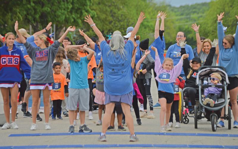 (THE GRAHAM LEADER | ARCHIVE PHOTO) Runners for the 1K Fun Run stretch as part of the Run for the Children in 2023. The 1K Fun Run will be held at 9 a.m. Saturday, April 27. The run is held within the inside of the Graham downtown square.