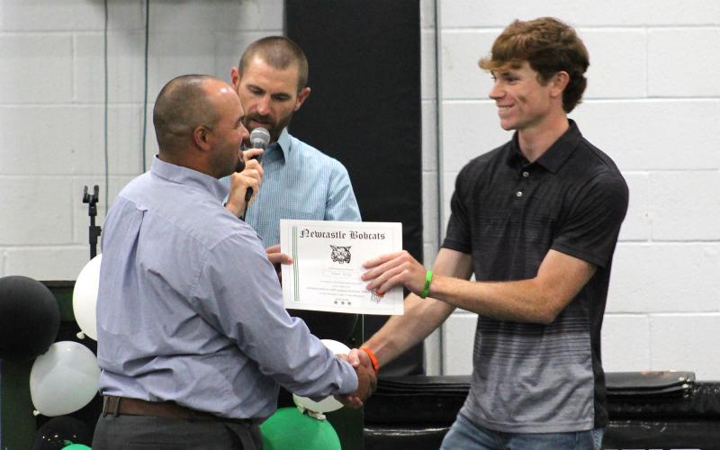 (TC GORDON | THE GRAHAM LEADER) Senior Isaac King (right) receives a certificate from coach Isiah Archer for one of the many sports in which he participated during the school year. Newcastle athletes were honored at the sports banquet Tuesday, May 21 for their performances all year.