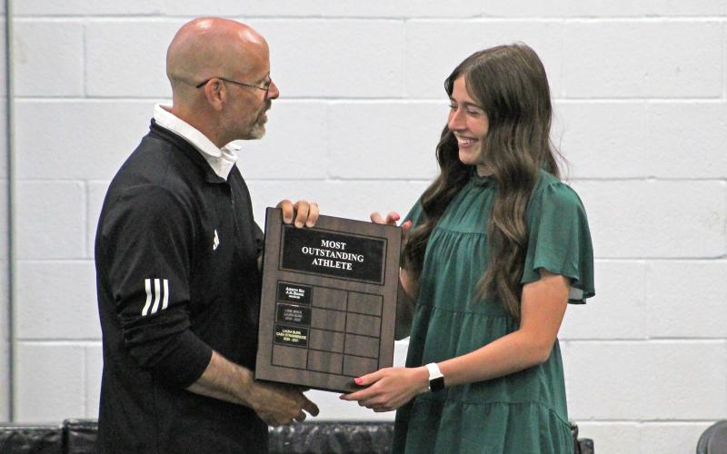 (TC GORDON | THE GRAHAM LEADER) Coach Ryan Dollar presents the Most Outstanding Female Athlete Award to his daughter Mattie Dollar at the Newcastle sports banquet Tuesday, May 21. Athletes from all sports throughout the school year were recognized for their contributions.