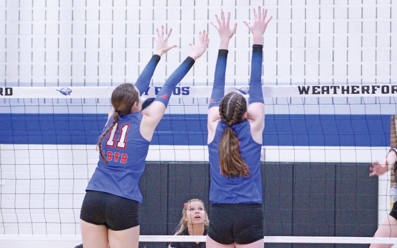 (TC GORDON | THE GRAHAM LEADER) Graham juniors Lillian Noble (11) and Emi Gordy (right) leap together to try to block a ball during the volleyball team’s area round playoff game.