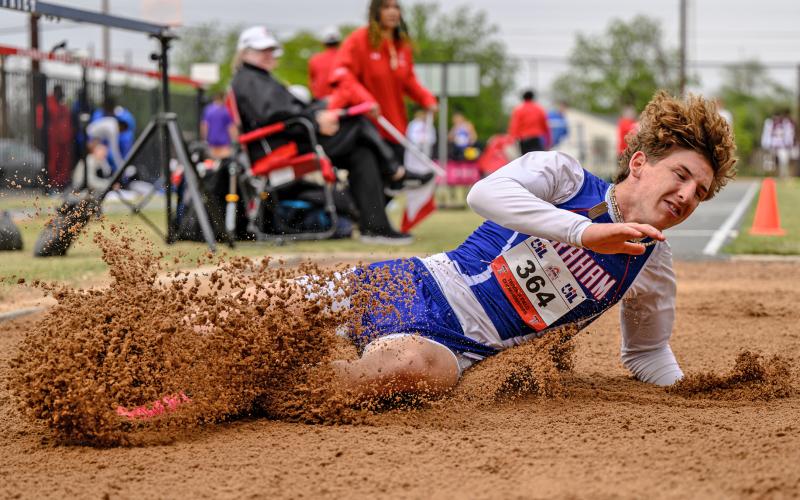 (DAVID FLYNN | CONTRIBUTED PHOTO) Peyton Kinman kicks up a cloud of sand after completing one of his long jump attempts at the regional meet in Lubbock. Kinman took fifth in the event.