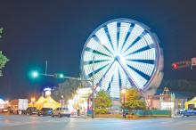 (THE GRAHAM LEADER | ARCHIVE PHOTO) The Ferris wheel at the Graham Lions Club Carnival lights up the corner of Second Street and Elm Street in 2023. The carnival will be returning to Graham next week starting Wednesday, May 8.