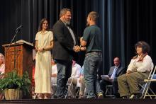(TC GORDON | THE GRAHAM LEADER) Michael Armstrong presents the Floy Hinson Memorial Scholarship to Zach Walker during the 38th annual Graham High School Scholarship Awards Ceremony held Monday, April 29 at Memorial Auditorium.
