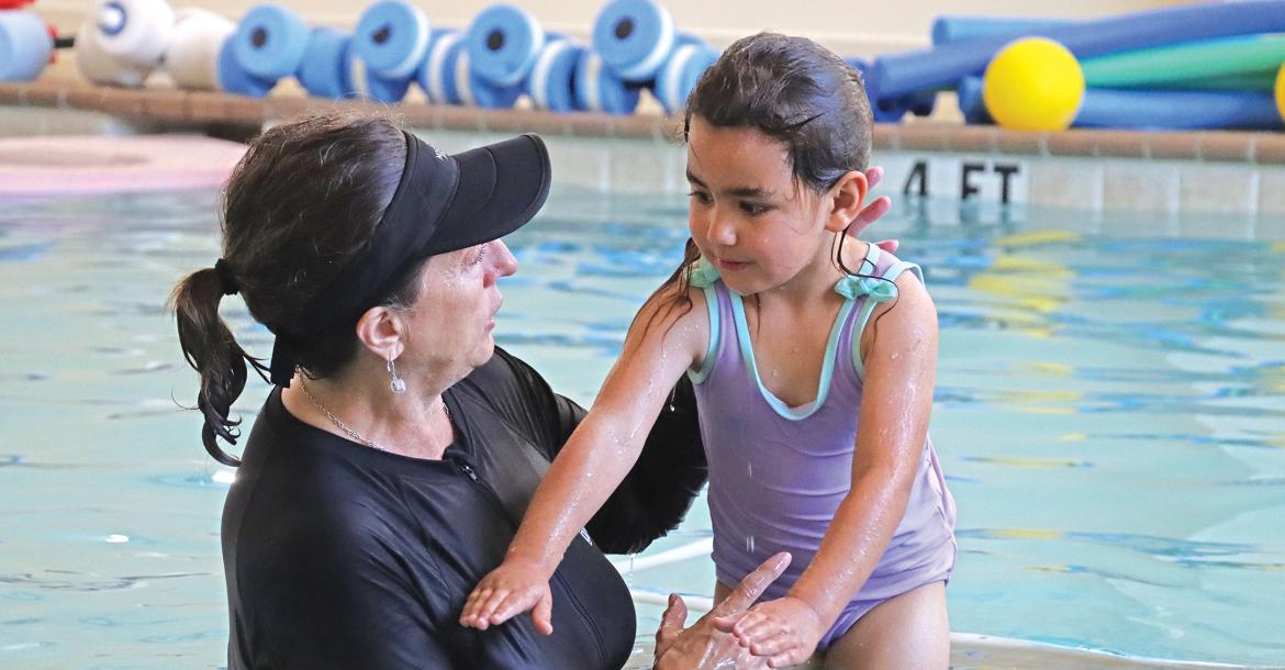 (THOMAS WALLNER | THE GRAHAM LEADER) Tracey Terasas speaks with a preschool student from Pioneer Elementary School during a swim boot camp held this week at the Graham Regional Medical Center Wellness Center.